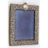 A large Victorian silver pierced frame, with central vacant cartouche, profusely chased and