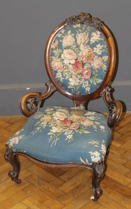 A Victorian walnut spoon back parlor nursing chair with serpentine fronted overstuffed seat, on