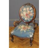 A Victorian walnut spoon back parlor nursing chair with serpentine fronted overstuffed seat, on