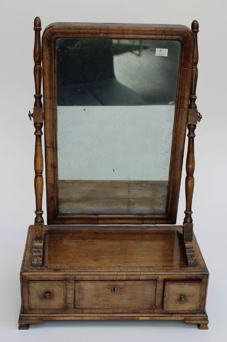 An early 19th century mahogany, boxwood and ebony strung toilet mirror, the cushion frame