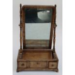 An early 19th century mahogany, boxwood and ebony strung toilet mirror, the cushion frame