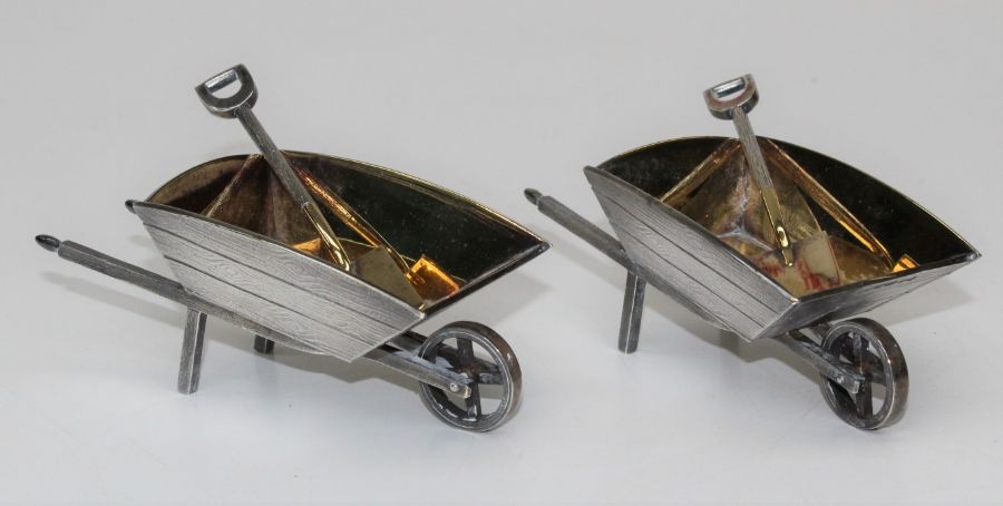 A pair of heavy gauge silver and silver gilt novelty wheelbarrow salts with matching shovels, London