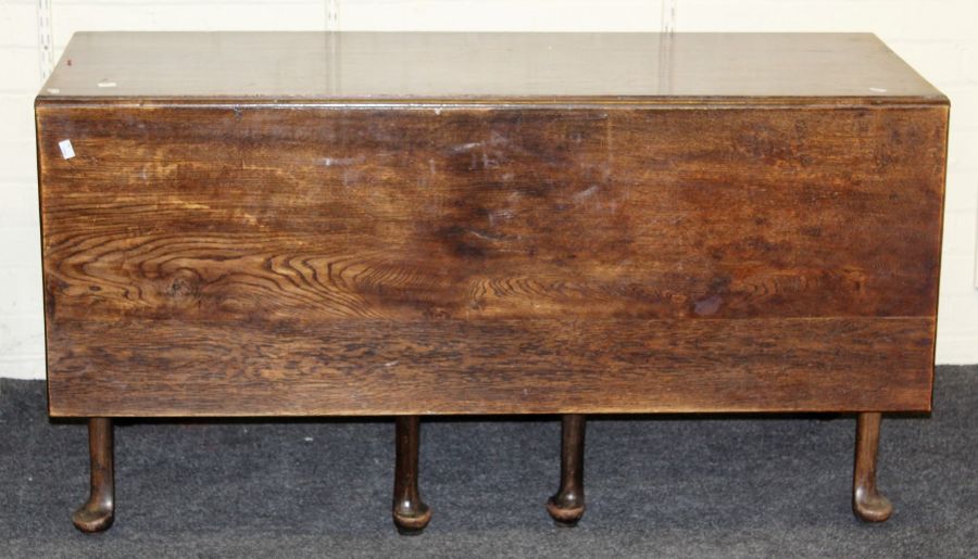 A George III oak dining table, rectangular top and twin drop leaves with double gate supports, on