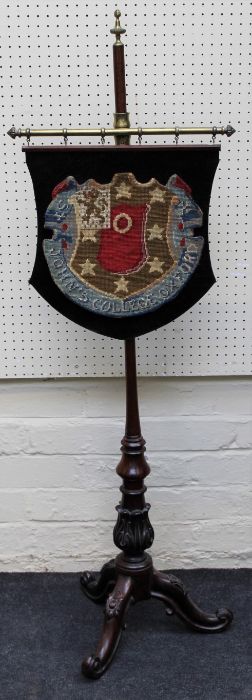 A Victorian rosewood pole screen, the gros point woolwork panel woven with the arms of John's