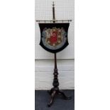 A Victorian rosewood pole screen, the gros point woolwork panel woven with the arms of John's