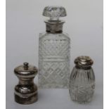 A silver mounted sugar castor, a silver pepper mill and a moulded glass decanter with silver collar,