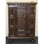 A 17th century and later oak cupboard, the block and moulded cornice above an arch panel door with