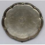 A Victorian silver plated waiter with chased crest and floral swags within a lobed beaded rim, on