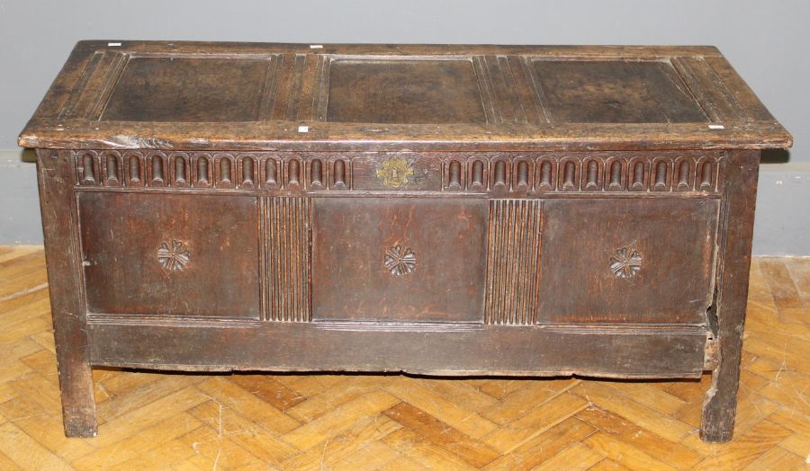 A late 17th century oak coffer, three panel top and front with stop fluted frieze, on stile supports