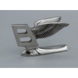 A chrome Bentley bonnet badge in the form of a winged upper case B, width 10.5cm