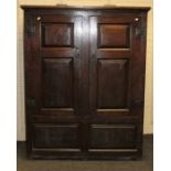An early 18th century panelled oak cupboard, the later cornice over fielded doors with nailed