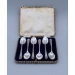 A set of silver spoons, boxed with a crossed golf club motif, hallmarked Sheffield 1932, sponsors