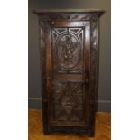 A 19th century Continental oak single wardrobe, the dentil cornice over panel door carved with Adam,