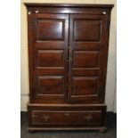 A late 18th century oak fielded panel cupboard of pegged construction, the pair of doors enclosing
