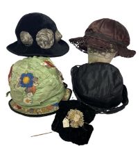 Four 1920s hats to include one (probably late 10s) hat in black silk with an upturned rouleau