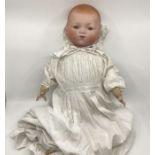 A Marseille Antique Bisque  21” head flange necked doll on stuffed frog leg shaped rose Cambric