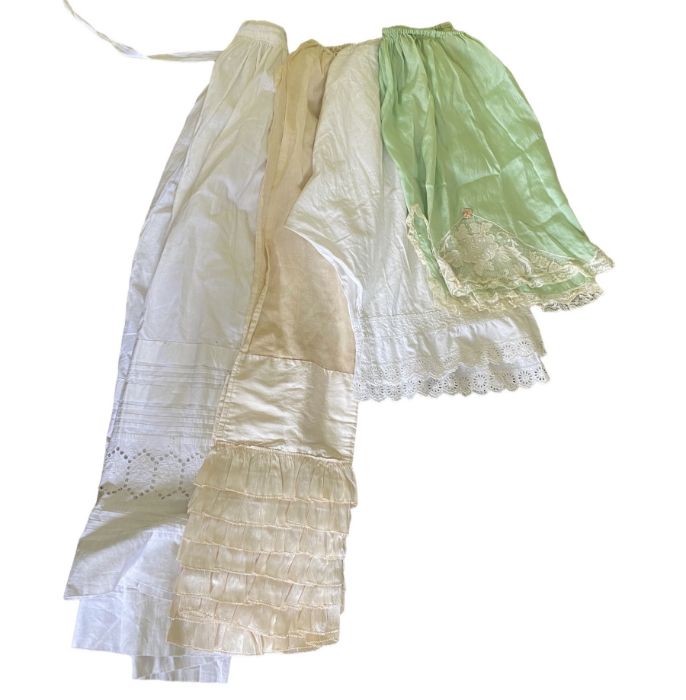 A group of lingerie to include a 1920s silk petticoat in green silk, a white cotton petticoat, white