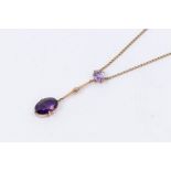A Edwardian amethyst and rose gold drop pendant, comprising a central oval cut pale amethyst