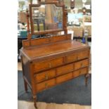 A mid 20th Century oak dressing table, two above two drawers, on turned legs, on casters, along with