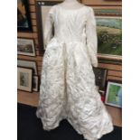 In its original box an early 1960's brocade wedding gown, fitted waist, large bow at base of back