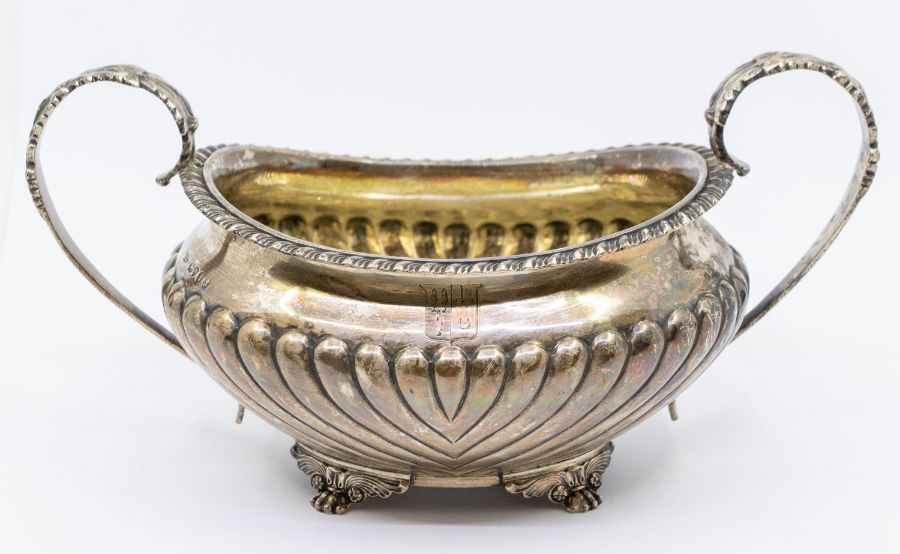 A George IV silver large two handled sugar basin, gadroon border, fluted body on foliate and paw