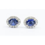 A pair of sapphire and diamond 18ct white gold stud earrings, comprising central oval mixed cut