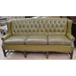 A Chesterfield high backed sofa in green, numerous signs of wear and hole to underside of one