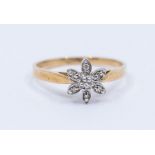 A diamond and 9ct gold (stamped 10k) ring, cpm[rising a diamond set floral cluster, setting approx