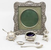 An Edwardian silver shaped square frame, easel back, the frame with profuse chased decoration,