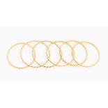 A collection of six high carat gold (tests as 21ct) baby bangles, comprising two different