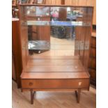 A 1970s teak display cabinet, with glazed doors above single protruding lower drawer, on block legs,