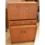 A 1970s teak hall bureau with dropdown writing top above single drawer and two bottom cupboard doors