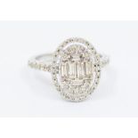 A diamond set 9ct white gold cluster ring, comprising an oval form set to the centre with a baguette