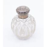 A Victorian silver topped cut glass perfume bottle, the ornate cover engraved with initials above