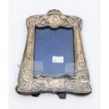 An Art Nouveau silver mounted frame, easel velvet back, the frame chased with flowers and foliage,