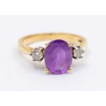 An amethyst and diamond 18ct gold dress ring, comprising an oval mixed cut amethyst to the centre