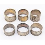 A collection of six late Victorian / early 20th Century silver napkin rings, one with strapwork