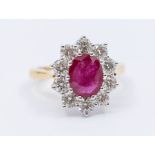 A ruby and diamond 18ct gold cluster ring, comprising a central oval mixed cut ruby approx 2.