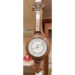 A mid 20th Century banjo barometer cased in oak with carved detail