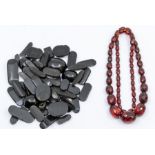 A cherry faceted Bakelite necklace, together with a set of loose jet pieces that form a choker