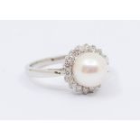 A pearl and diamond set 9ct white gold dress ring, comprising a central round white cultured pearl