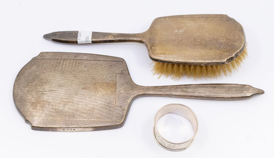 An early 20th century silver dressing table hand mirror and matched brush, similar engraved