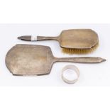 An early 20th century silver dressing table hand mirror and matched brush, similar engraved