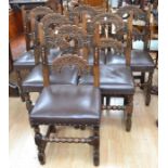 A set of six oak Jacobean-style dining chairs with leatherette seats.