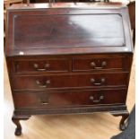 A Georgian style mahogany slopefront bureau, fitted interior above two short and two long drawers on