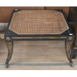 A Regency style caned foot stool on castors, with cushion