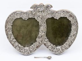 An early 20th Century possibly American silver double heart shaped frame, ribbon tied chased