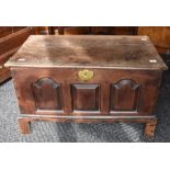 A small, early 18th century, oak coffer on block feet with a three-panelled front and a brass lock