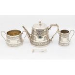 A Victoria Anglo-Indian style three piece silver tea service comprising teapot, sugar bowl, milk