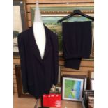 A Chanel Boutique black trouser suit; padded shoulders, large style jacket, flap pockets, Chanel